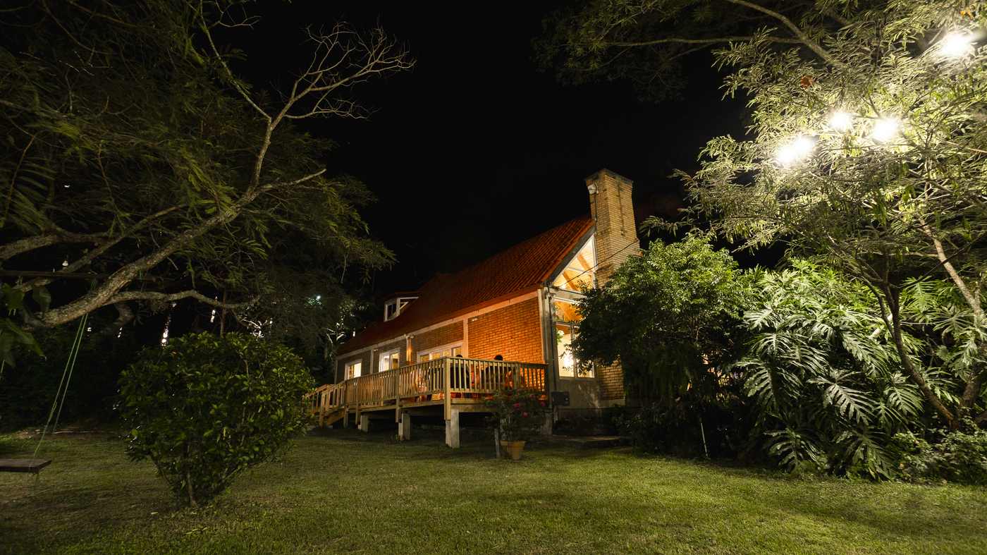 La casa iluminada de noche entre el bosque de pino