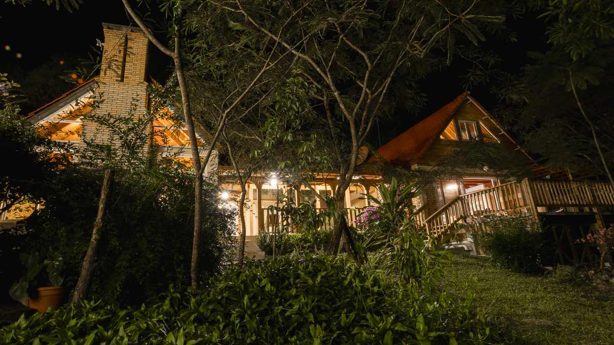 La casa iluminada de noche, vista desde el jardín