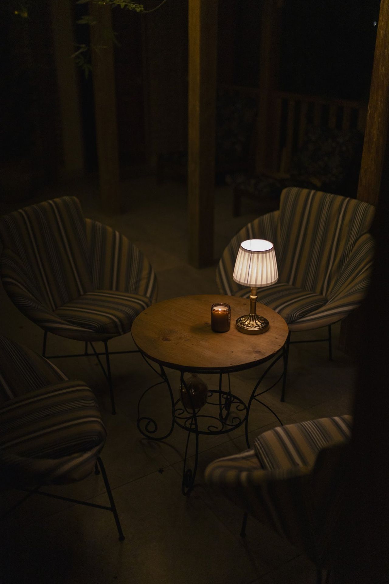 La terraza de noche, con la lamparita sobre la mesa de hierro
