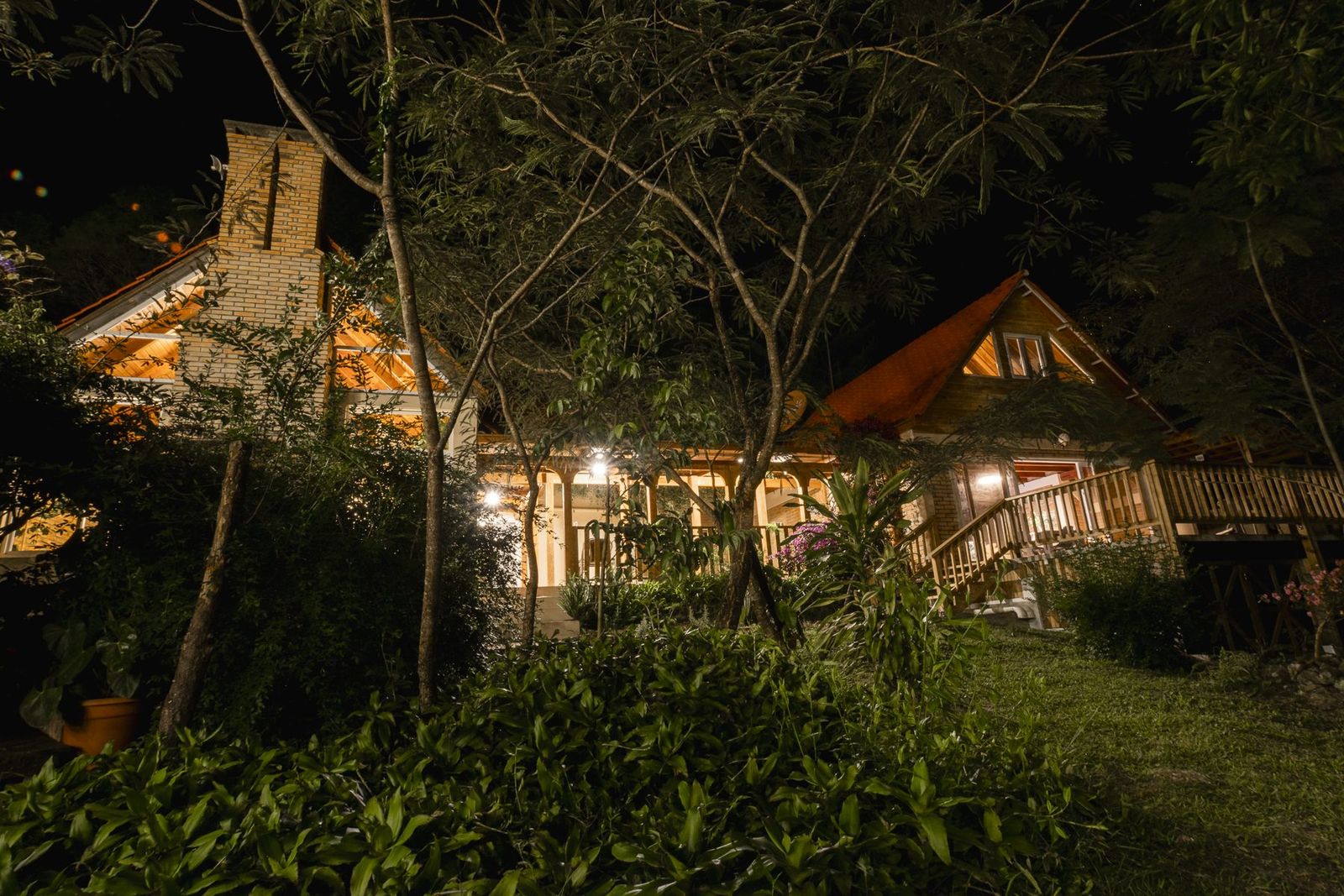 La casa y El Garaje iluminados de noche vistos desde el jardín