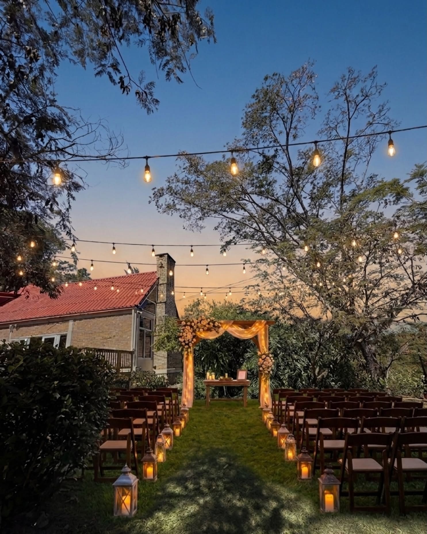 Ceremonia al atardecer junto a la casa: arco de flores, faroles y sillas de madera bajo las luces