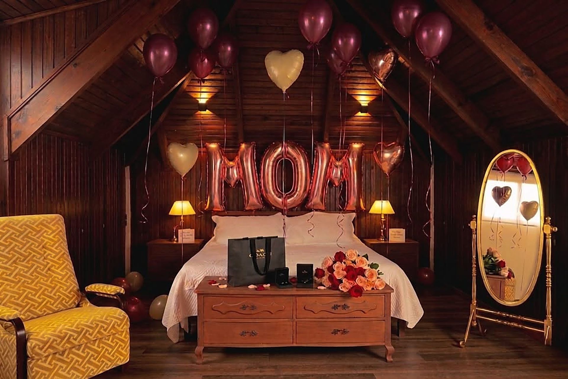 Cuarto con techo de madera decorado con globos que dicen MOM, rosas y regalos sobre la cama