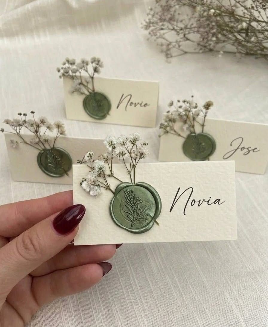Tarjetas de lugar con sello de cera verde y flores secas